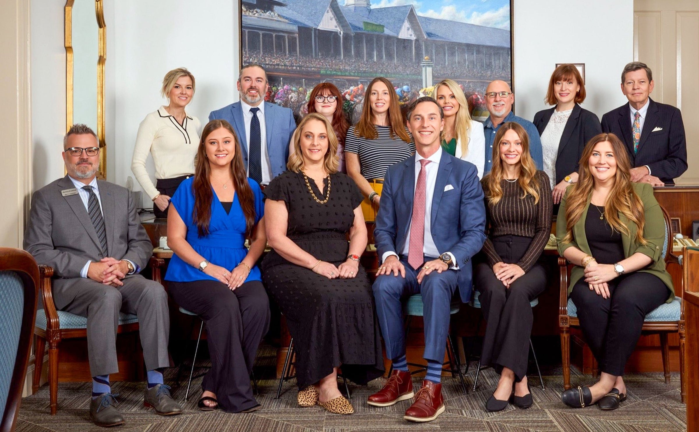 Group of professionals posing for a photo in an office setting with a large screen in the background.